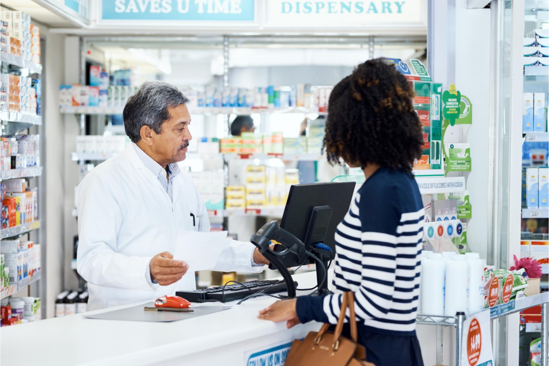 Staffed grocery checkout lane with register and customer paying