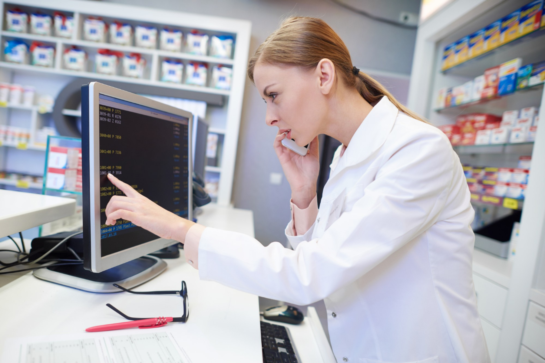 Retail associate assisting a customer at a support desk with payment terminal
